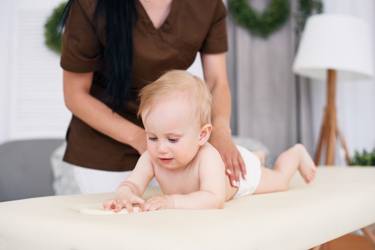 health-care-and-medical-concept-happy-baby-having-massage-with-professional-female-masseuse